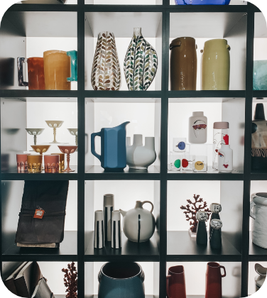 正方形に区切られた棚の中に、花瓶やグラス、水差しなどの雑貨が並べられた写真